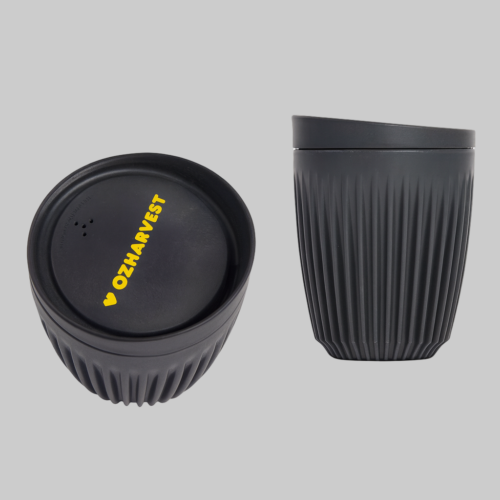 Black reusable cup with textured design and lid featuring 'OzHarvest' branding on a white background.