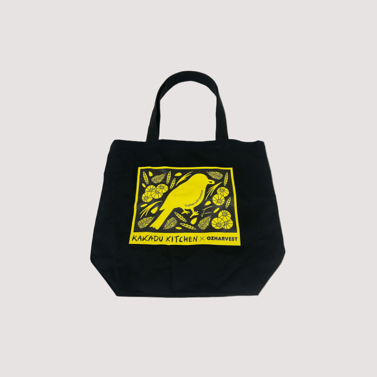 Black tote bag with yellow graphic on a light gray background 2