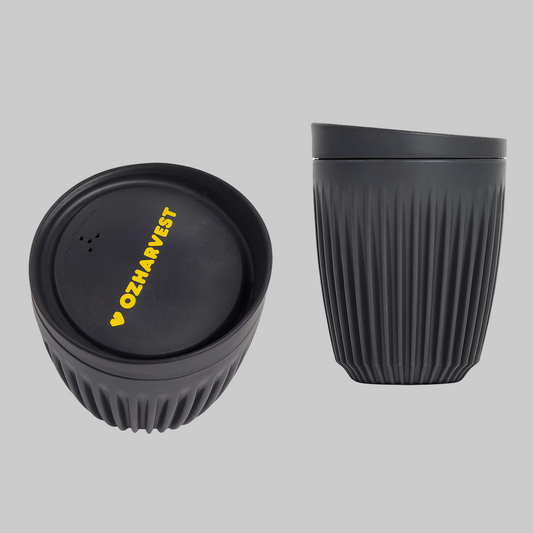 Black reusable cup with textured design and lid featuring 'OzHarvest' branding on a white background.