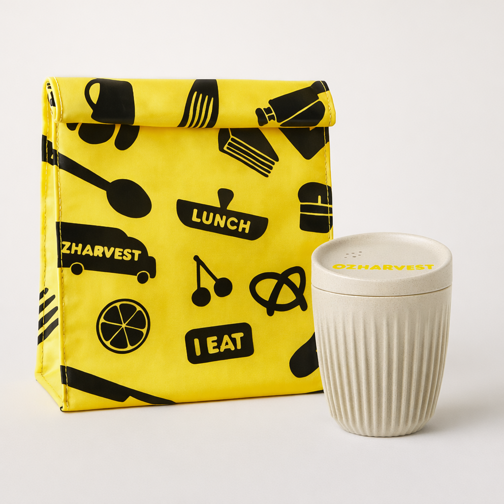 Yellow lunch bag with black patterns and a white container on a light gray background