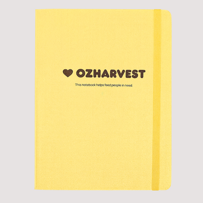 Yellow notebook with OzHarvest branding on a white background